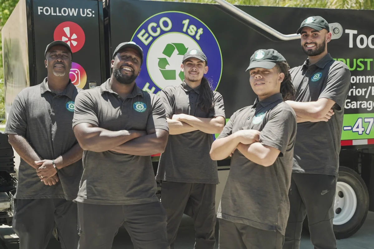 Five Eco 1st Hauling team members standing together beside their branded truck