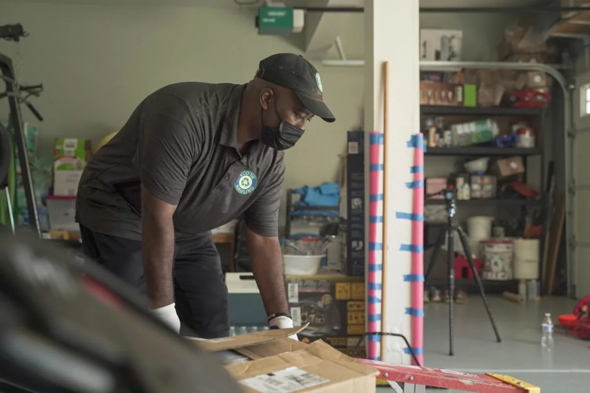 An Eco 1st team member handling a large item inside a garage