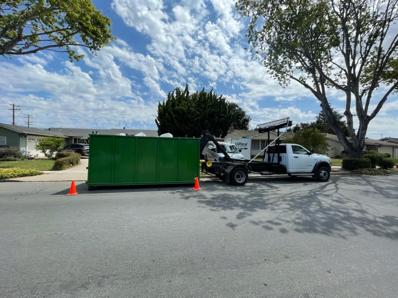 A green James Junk Removal container at a residential cleanout