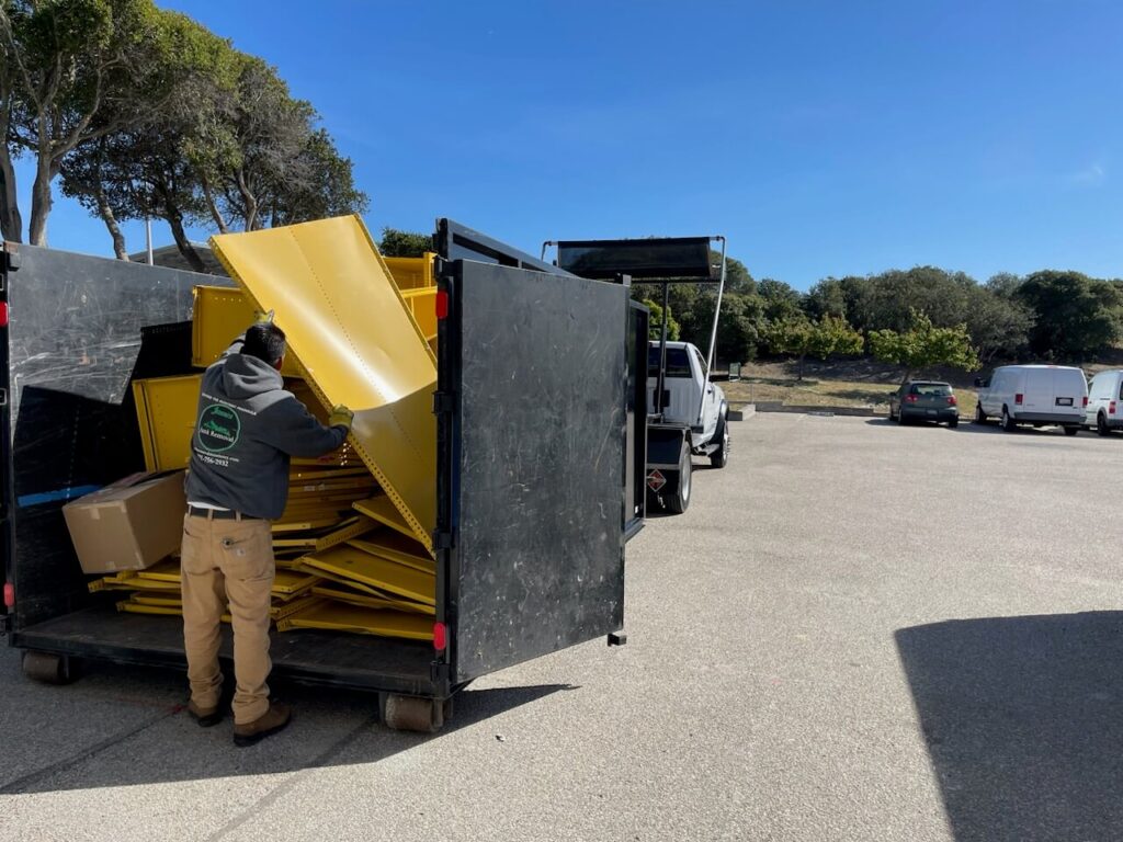 The team loading the dismantled yellow shelving into their hauling truck