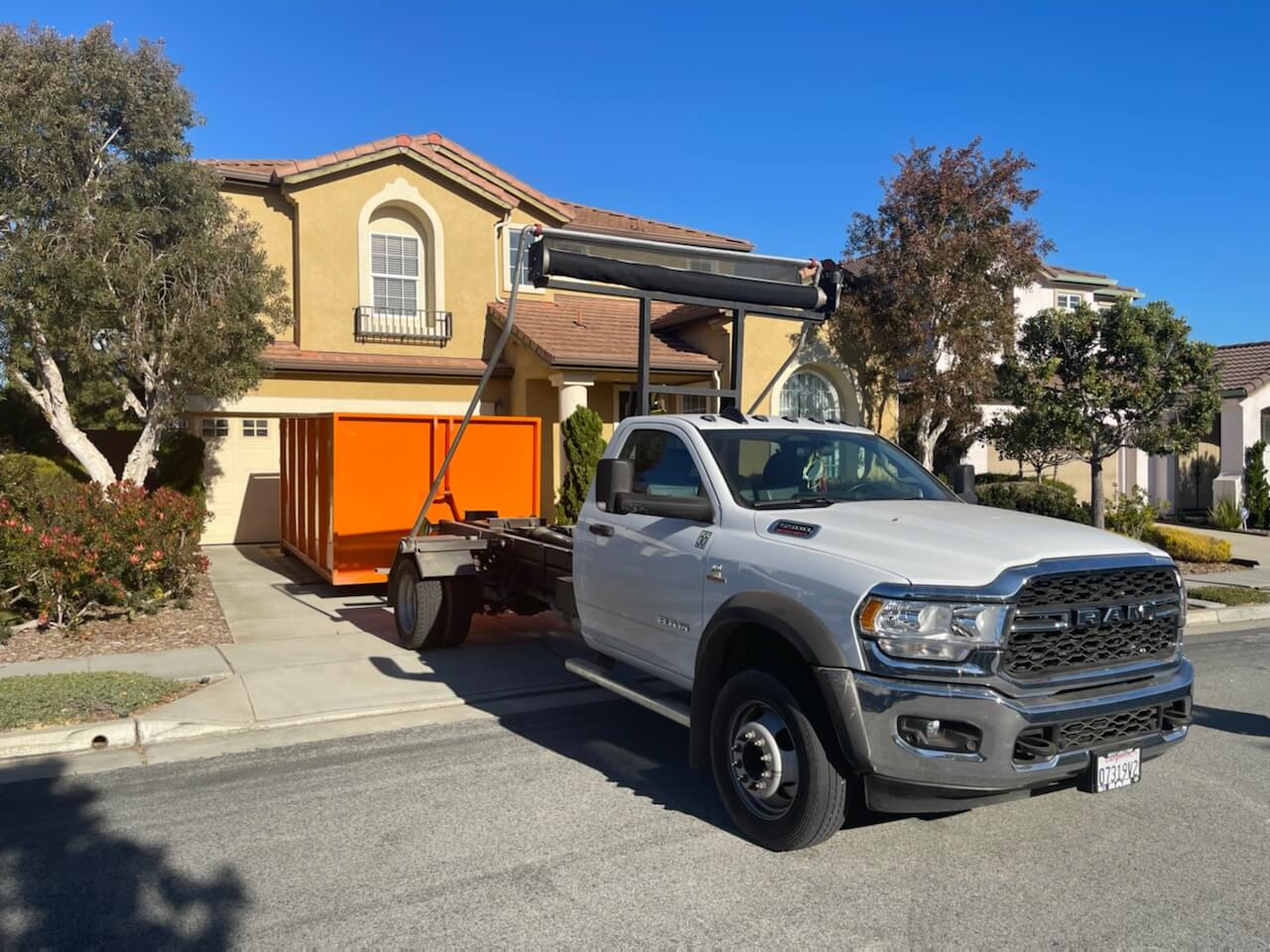 James Junk Removal truck delivering a container at a home