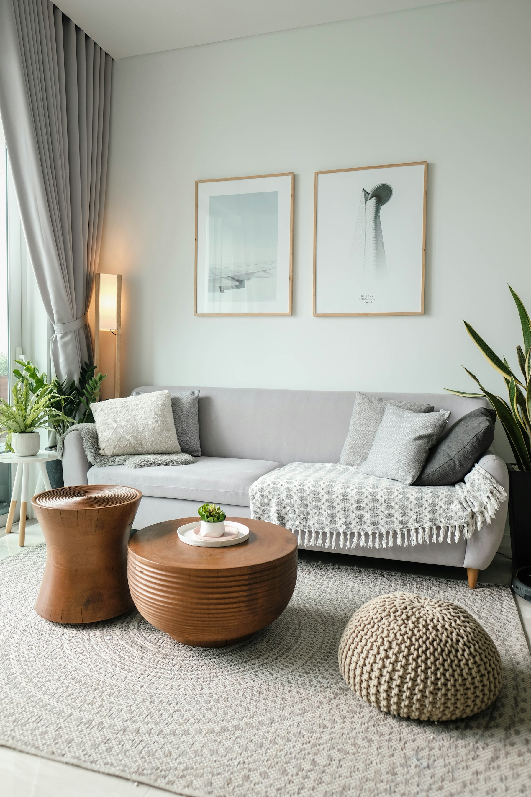 Illustrative living room with a light sofa, plants and natural wood furniture