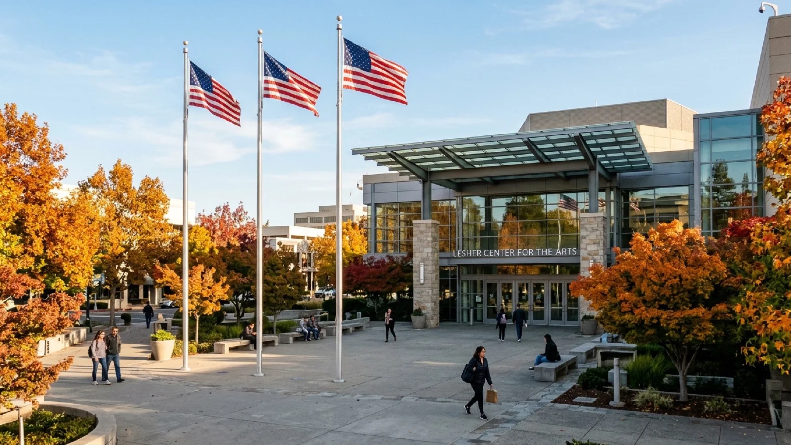 Exterior plaza of the Lesher Center for the Arts in Walnut Creek with American flags and autumn trees along Civic Drive
