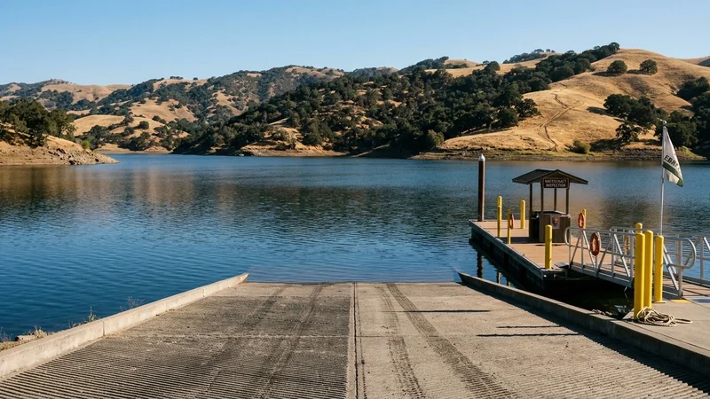 Scenic view of Lake Del Valle boat launch ramp and blue reservoir waters surrounded by oak hills in the Tri-Valley